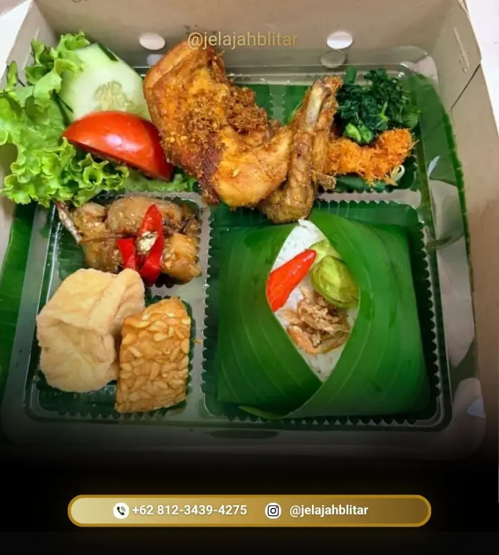 Nasi kotak dengan ayam goreng kremes, tahu, tempe, dan lalapan
